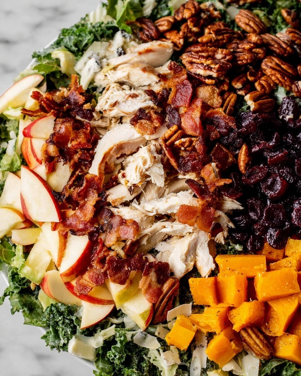 The image shows a close-up view of a colorful salad layered on a white plate, set on a white marbled surface. The base layer consists of green leafy kale scattered across the plate. On top of this, there are bright red apple chunks cut into small wedges, toasted brown pecans clustered in one section, crispy golden-brown bacon pieces spread unevenly, and shredded white chicken breast placed prominently in the center. The salad is accented with dark purple dried cranberries and bright orange roasted butternut squash cubes placed near the bottom. Small, light ivory cheese shavings can be seen on the edge, adding texture and color contrast. The overall look is fresh, vibrant, and textured. photo taken with an iphone --ar 4:5 --v 7