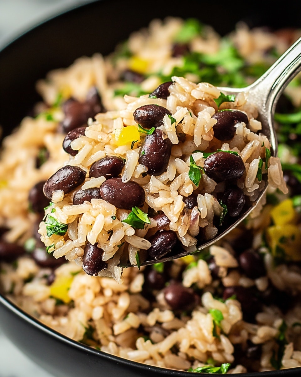 A close-up view of a spoonful of rice and black beans mixture. The dish shows soft, fluffy light brown rice grains mixed evenly with small, shiny black beans. Small bits of yellow bell pepper and fresh green herbs are scattered throughout, adding pops of color. The texture is moist but not soggy, with the herbs providing a fresh contrast to the smooth beans and tender rice. The background is blurred, showing more of this mixture in a black bowl on a white marbled surface. photo taken with an iphone --ar 4:5 --v 7