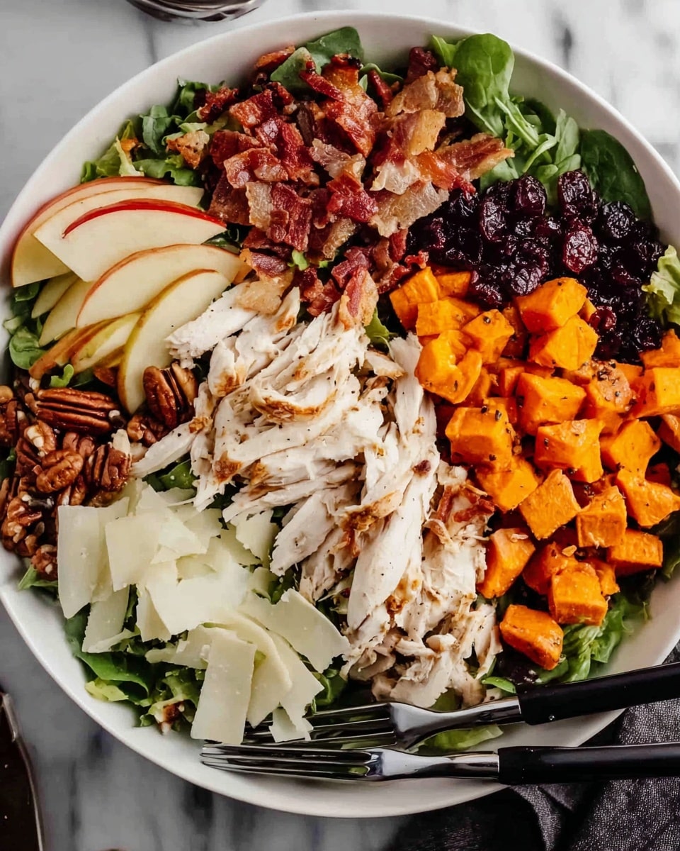A white bowl filled with a salad arranged in clear layers on a white marbled surface; the base layer is a mix of green leafy vegetables, topped with shredded white chicken laid in a row; to the right of the chicken are small bright orange roasted sweet potato cubes with a slightly charred texture, next to a dark row of dried cranberries; diced red and white apple pieces are placed above the chicken, beside crispy brown bacon strips clustered together; a pile of whole pecans is on the left side of the bowl, and thin white shaved cheese slices are arranged in two sections, one near the pecans and one near the sweet potatoes, accompanied by black salad tongs resting on the bowl’s edge; photo taken with an iphone --ar 4:5 --v 7