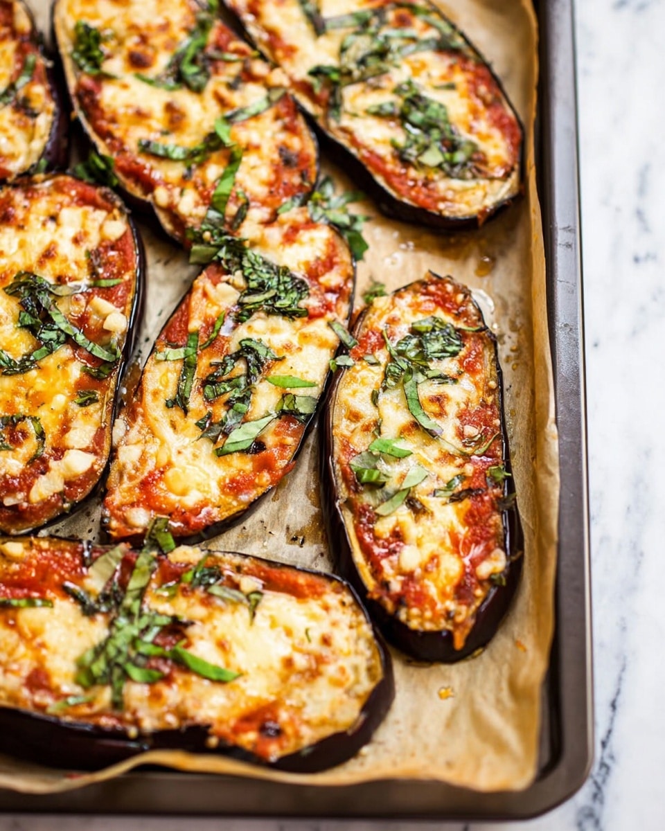 The image shows several slices of eggplant cut lengthwise, arranged on a baking tray lined with parchment paper. Each slice has a dark purple-brown outer skin, topped with a layer of bright red tomato sauce, followed by a melted creamy yellow layer of cheese with browned spots. There are scattered green fresh herbs and wilted pieces of spinach on top, adding small patches of green color to the dish. The textures show a mix of soft roasted eggplant beneath the smooth sauce and melted cheese, which is slightly bubbly and golden in some areas. The baking tray is placed on a white marbled surface. photo taken with an iphone --ar 4:5 --v 7